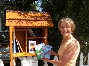 Judith Desjardins poses with books in front of her Little Free Library on Pearl Street in Santa Monica. She opened the tiny, free community library in January. (Photo by Saul Rubin)