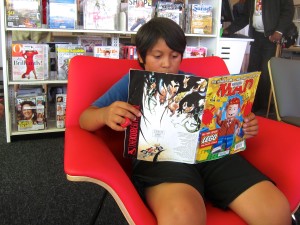 Pico resident Jorge Diaz, 10, catches us on some important reading during opening ceremonies of the Pico Branch library on Saturday.