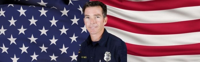 Desktop Header-Fire Engineer Dominic Smith in front of American flag header length